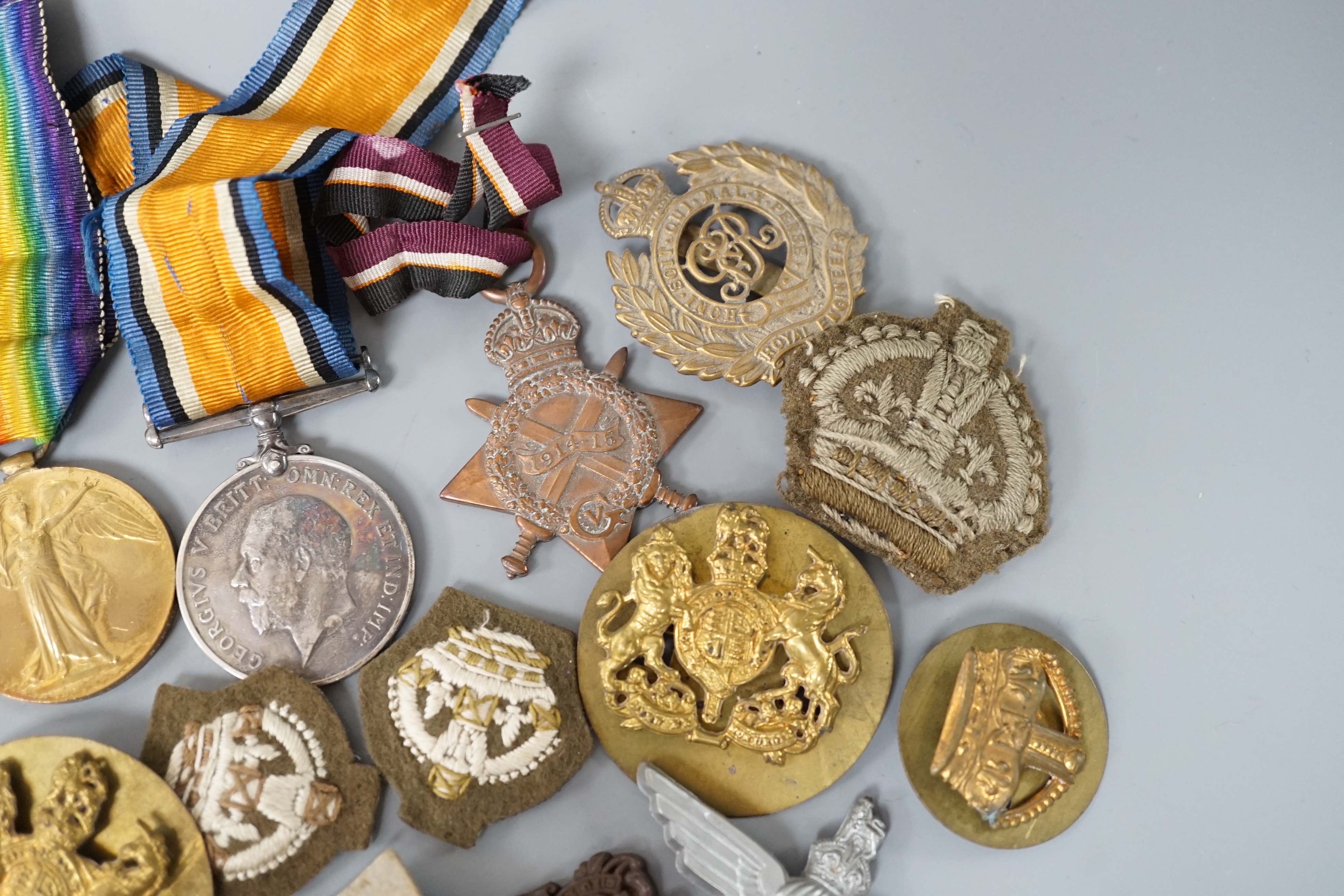Two WWI medals, collection of cap badges and buttons, Queen Mary tobacco tin and a 66th Infantry Brigade concert party clickety clack cigarette case etc